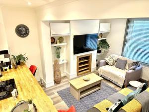 a living room with a couch and a tv at Modernised cottage Sleeps Six in Ore