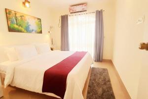 科尔瓦Colva Blossom 2BHK Apartment with Gym,Wifi and 5min walk to the famous Colva Beach的带一张大床和一扇窗户的卧室