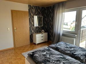 a bedroom with a bed and a dresser and a window at Eifel Ferienwohnung Thiel in Oberstadtfeld