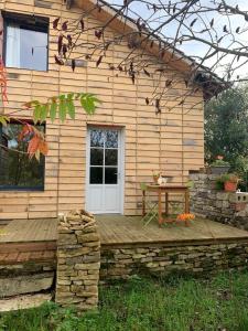 a wooden deck with a table in front of a house at séjour nature au Shed - Sornay - Haute Saône 