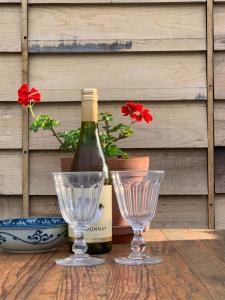 a bottle of wine and two wine glasses on a table at séjour nature au Shed - Sornay - Haute Saône 