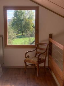 a chair sitting in a room with a window at séjour nature au Shed - Sornay - Haute Saône 