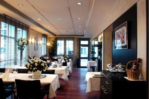 Hotel Ochsen في أوستر: مطعم بطاولات بيضاء وكراسي ونوافذ