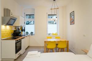 a kitchen with a table and yellow chairs at Nahe Boxhagener Platz für 4 Personen in Berlin