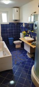 a blue tiled bathroom with two sinks and a tub at House Lipo in Makarska +34 photos