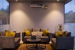 FabHotel Resort De Ashvem في مورجيم: غرفة معيشة مع أريكة ووسائد صفراء