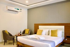sypialnia z dużym białym łóżkiem z żółtymi poduszkami w obiekcie FabHotel Resort De Ashvem w mieście Morjim