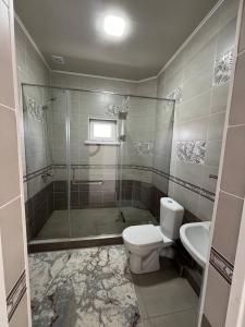 y baño con ducha, aseo y lavamanos. en Гостевой дом Дастан, Guest House Dastan en Bulan Sogottuu