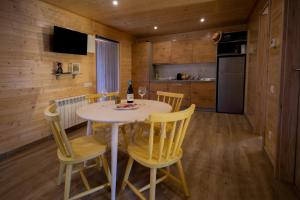 uma cozinha e sala de jantar com mesa e cadeiras em Bungalows Laspaúles em Laspaúles