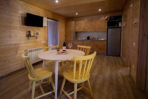a kitchen and dining room with a table and chairs at Bungalows Laspaúles in Laspaúles