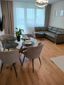 ein Wohnzimmer mit einem Tisch, Stühlen und einem Sofa in der Unterkunft Apartament 8 Piętro self check-in, parking in Rzeszów