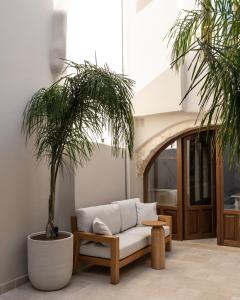 a living room with a couch and two palm trees at Cortiletto Timeless Suites in Rethymno Town