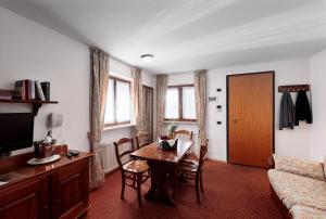 ein Wohnzimmer mit einem Tisch und einem Sofa in der Unterkunft Hotel Miramonti Corvara in Kurfar