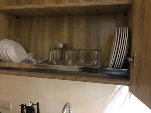 uma prateleira de cozinha com copos e pratos em Al-Andalos Studio em New cairo