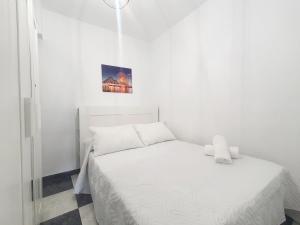 ein weißes Schlafzimmer mit einem weißen Bett und einem Bild an der Wand in der Unterkunft Avenida Principal con Wifi y Smart Tv - By Aloha Palma in Águilas