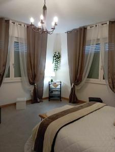 Schlafzimmer mit einem Bett mit Vorhängen und einem Kronleuchter in der Unterkunft Tirano Express Apartments in Tirano