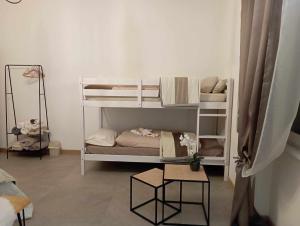 Zimmer mit 2 Etagenbetten und einem Tisch in der Unterkunft Tirano Express Apartments in Tirano