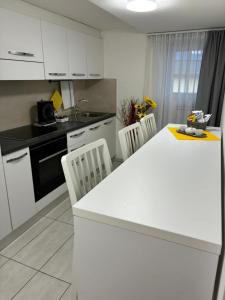 a kitchen with white cabinets and a white counter top at RESIDENZA GIOVANNI in Contone