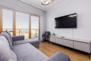 a living room with a couch and a flat screen tv at Nadmotławie Chic Apartment in Gdańsk