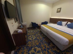 a hotel room with a bed and a flat screen tv at فندق ود العزيزية in Al ‘Azīzīyah