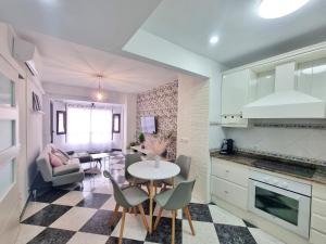 eine Küche und ein Wohnzimmer mit einem Tisch und Stühlen in der Unterkunft Avenida Principal con Wifi y Smart Tv - By Aloha Palma in Águilas