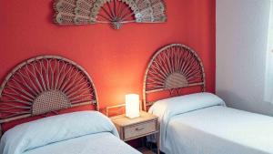 two beds in a room with red walls at Casa Rural el Guarda in Madrid +33 photos