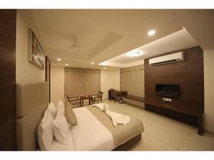 Hotel Jayson Metoda في راجكوت: غرفة في الفندق مع سرير وغرفة طعام