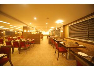 Hotel Jayson Metoda في راجكوت: غرفة طعام مع طاولات وكراسي في مطعم