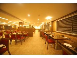 a dining room with tables and chairs in a restaurant at Hotel Jayson Metoda in Rajkot