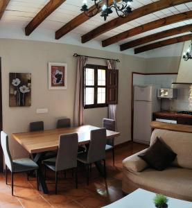 cocina y sala de estar con mesa y sillas en Casa Villazo I, en Almáchar
