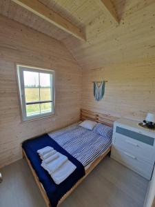 a small bedroom with a bed in a wooden room at BobolinLove in Bobolin