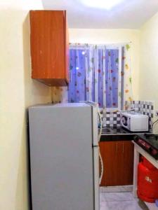 a kitchen with a white refrigerator and a window at Leo's Enchanting homes in Mombasa