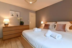 a bedroom with a large white bed with two lamps at Appartement The Fairytale in Colmar