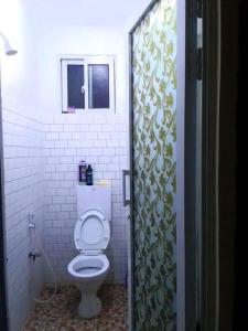 a bathroom with a toilet in a white bathroom at Leo's Enchanting homes in Mombasa