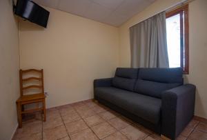 a living room with a couch and a television at Camping Rural Ria de Arosa 2 in Ribeira