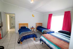 Un dormitorio con dos camas y una ventana. en Heide 15, en Struisbaai
