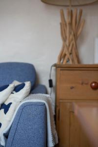 a bedroom with a blue couch and a wooden dresser at Elegant 2 bed in the heart of Falmouth - sleeps 4 in Falmouth