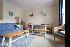 a living room with a blue couch and a table at Elegant 2 bed in the heart of Falmouth - sleeps 4 in Falmouth