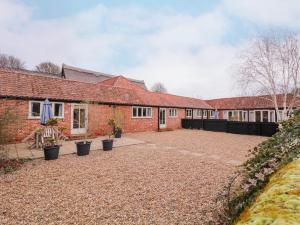 eine Reihe von Backsteingebäuden mit Topfpflanzen im Innenhof in der Unterkunft Little Owl Cottage in Saxmundham