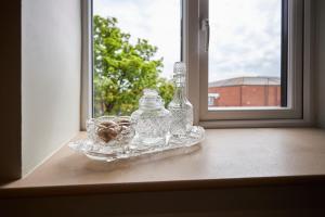 a glass bottle and a bowl on a window sill at The Believe Boutique (Believe Bar & Bedrooms) in Redcar