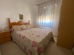 a bedroom with a bed and a dresser and a window at La Goleta Solo Familias Serviplaya in Playa de Xeraco