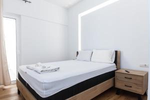 a bedroom with a large bed with white sheets at Kallithea Modern Living with Designer Touch in Athens