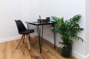 Un escritorio negro con una silla y una planta en Kallithea Modern Living with Designer Touch en Atenas
