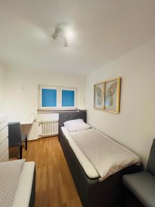 a bedroom with a bed and a couch and two windows at Ferienapartment Linz am Rhein in Linz am Rhein