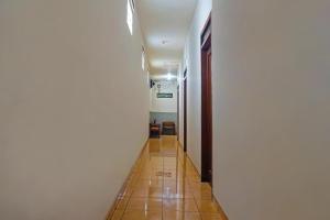 a hallway with a long white wall and a tile floor at Bright Batavia in Jakarta