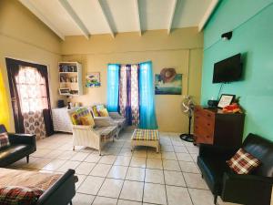 salon z meblami i telewizorem w obiekcie La Kaye Nou by SMO Wellness w mieście Soufrière