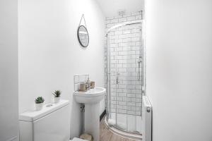 a white bathroom with a toilet and a shower at Modern 5-Bedroom property Ideal for working professionals families & tourists in Whitefield