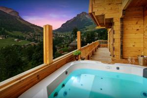 a jacuzzi tub on a deck with a view at Cristal des Neiges La Clusaz - OVO Network in La Clusaz