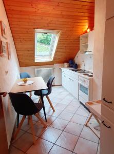 cocina con mesa, sillas y ventana en Haus Berger en Seebach