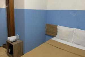 een slaapkamer met een bed met een blauwe muur bij Bright Batavia in Jakarta